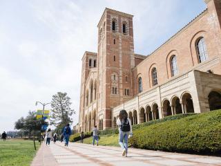 campus residents stroll by the towers of Royce Hall